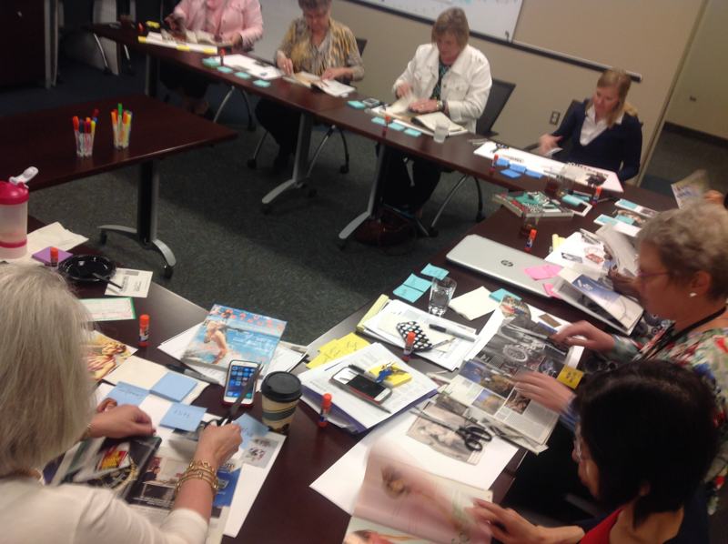 Participants at a table covered in images and notes.
