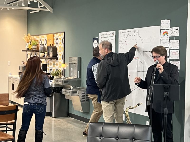 A resident points to a spot on a hand-drawn map of Anderson while others look on.